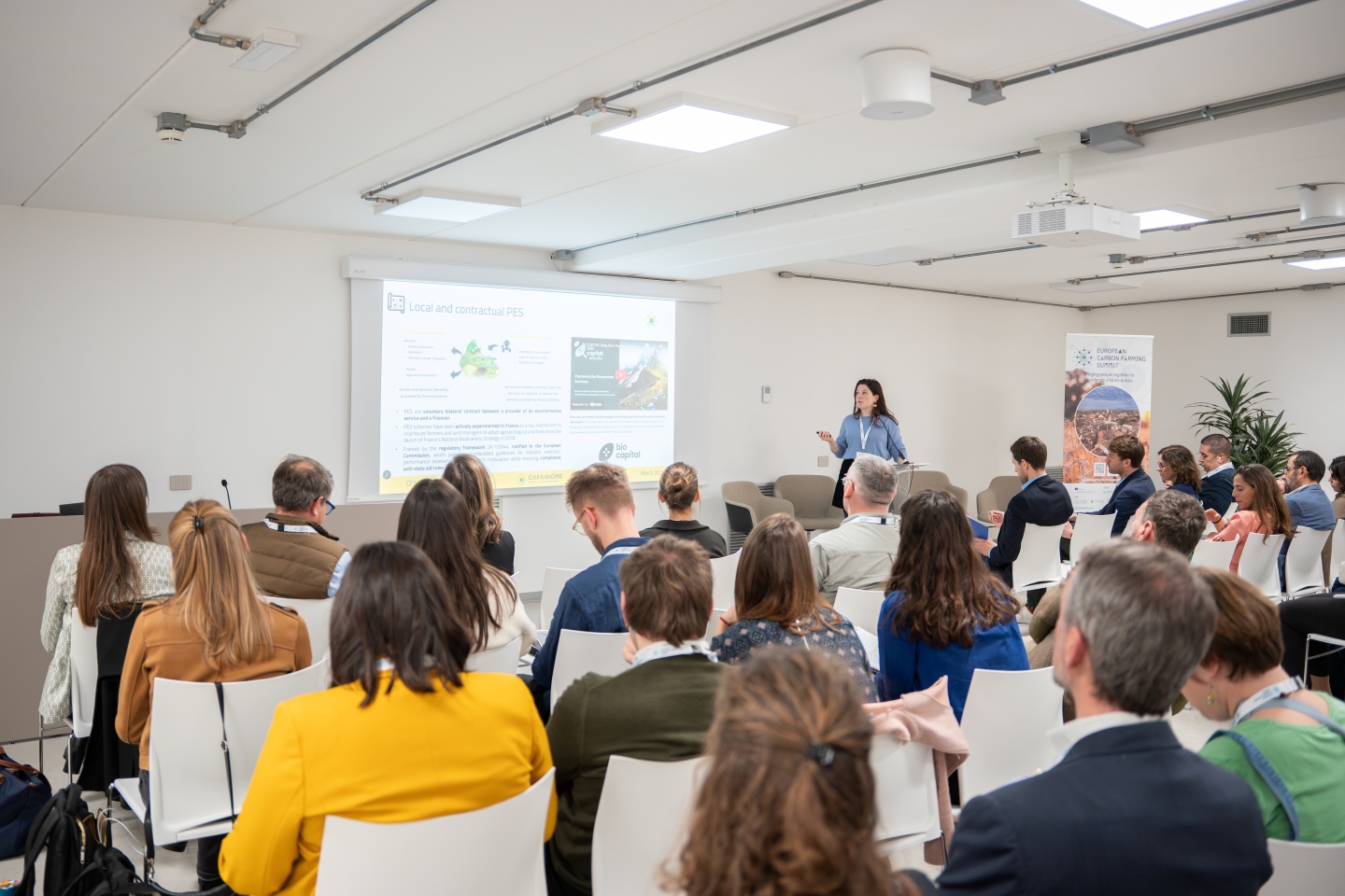 Researchers on a conference stage presenting their findings to an audience.