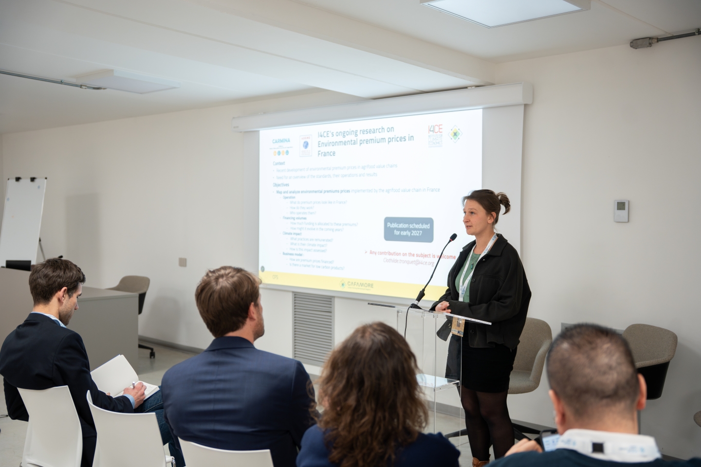 Researchers on a conference stage presenting their findings to an audience.