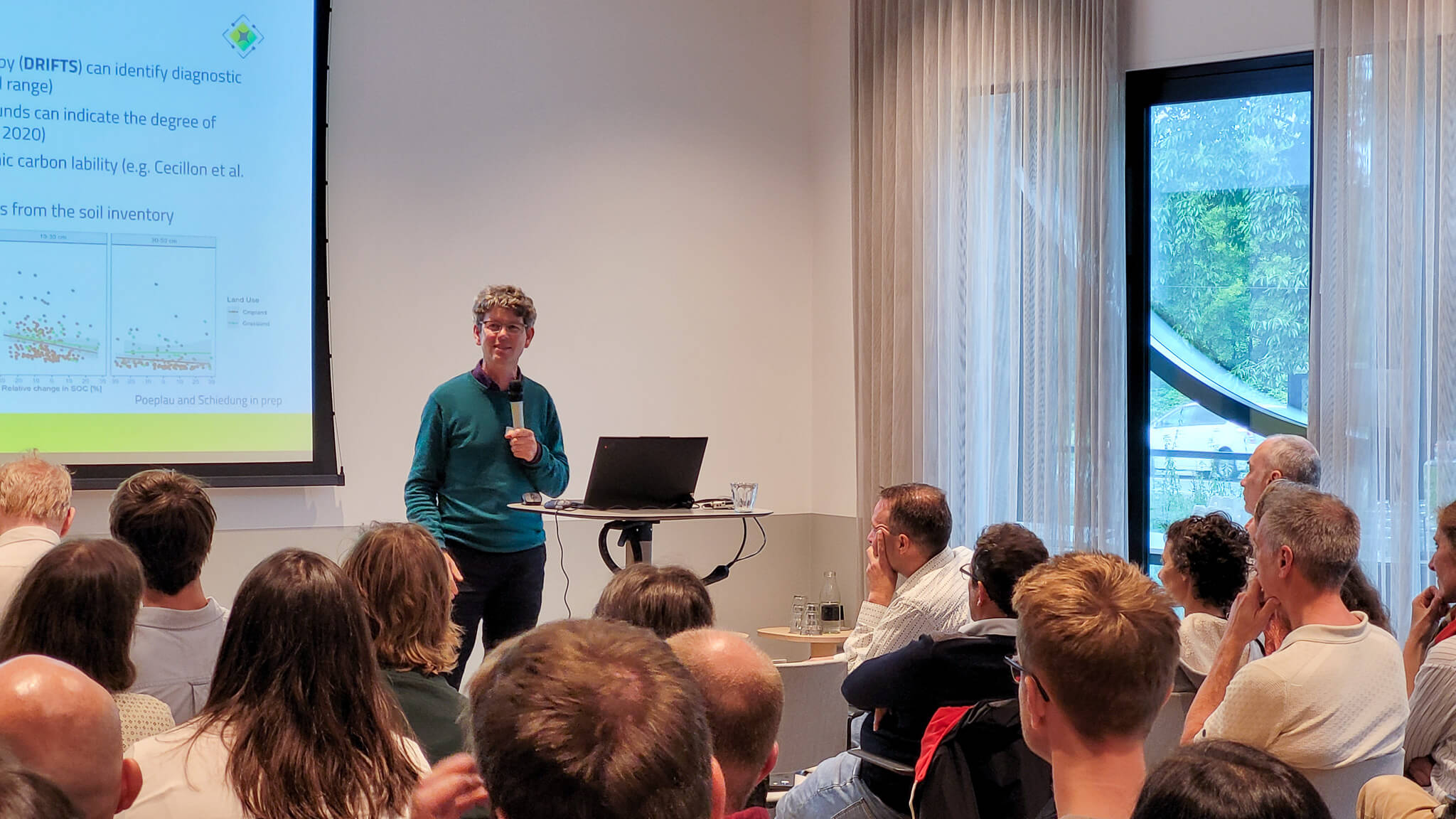 A man presenting to an audience, engaging with the group while using visual aids to enhance his message.b